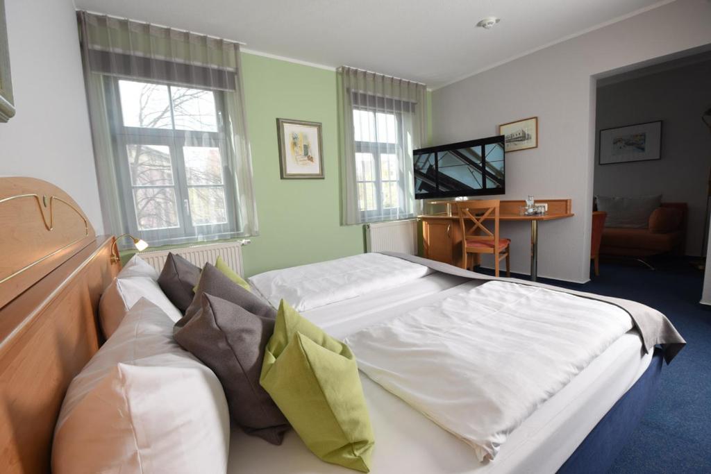 魏玛安娜·阿玛利亚酒店的一间卧室配有一张大床和电视