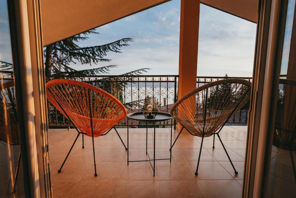 奥赫里德Villa Pandora的阳台配有两把椅子和一张桌子
