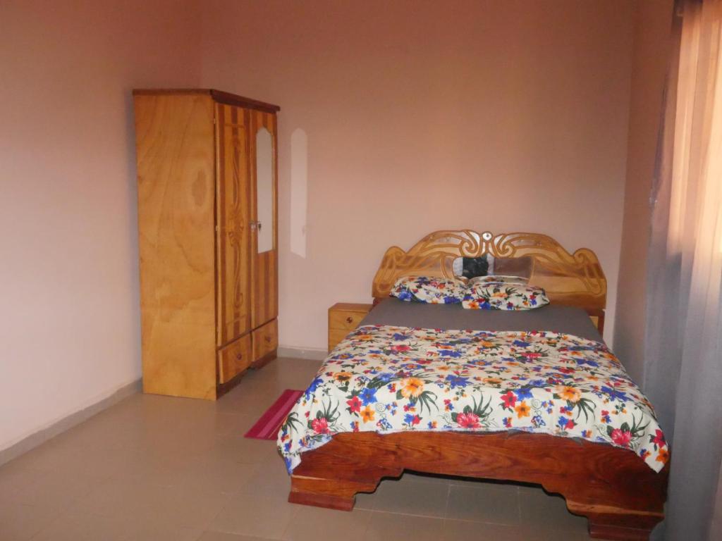 巴马科Appartement et Chambres的一间卧室配有木床和木柜
