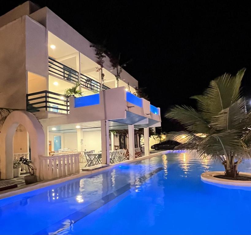 卡莫辛Pousada La Grécia的夜间带游泳池的别墅