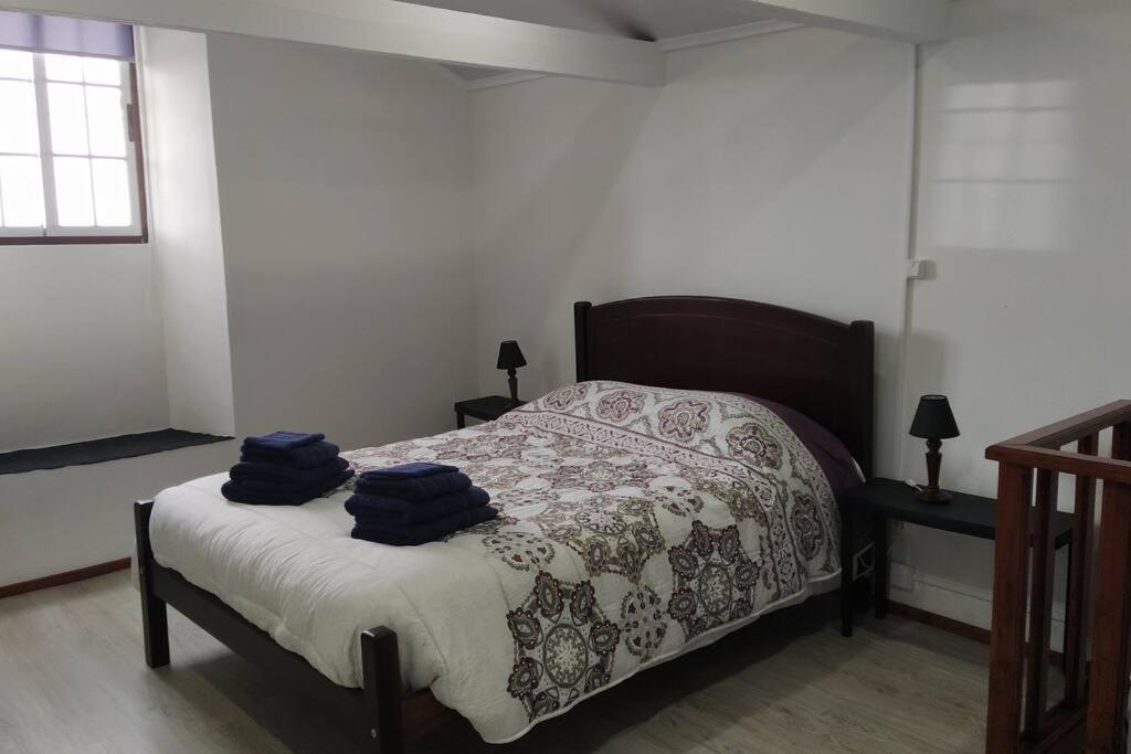 Praia da GraciosaCasa dos Fenais的一间卧室配有一张带2条蓝色毛巾的床
