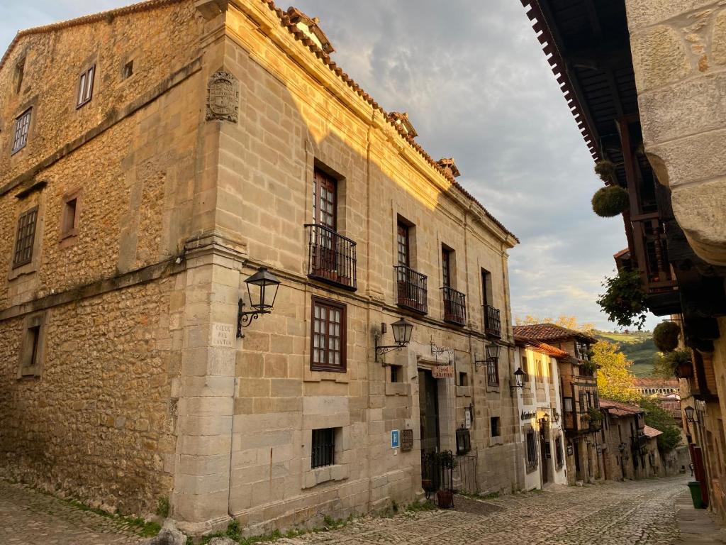 桑提亚纳德玛阿尔塔米拉酒店的街道上一座带窗户的古老石头建筑
