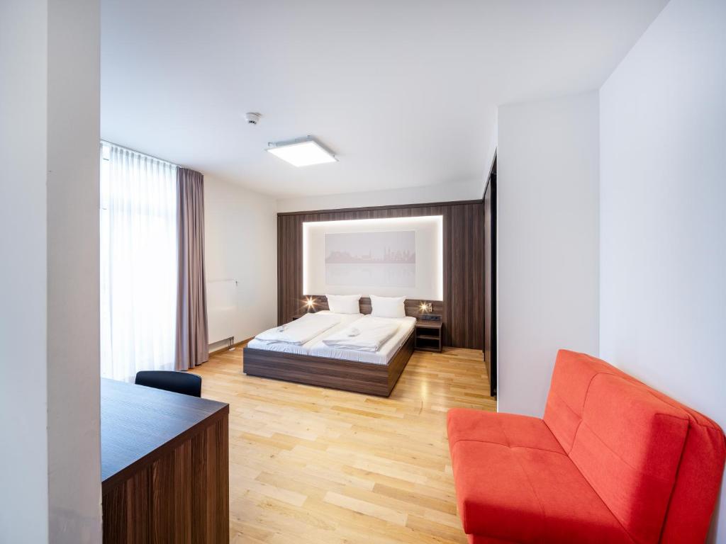 海德堡博丁哈斯7天酒店的一间卧室配有一张床和一张红色椅子