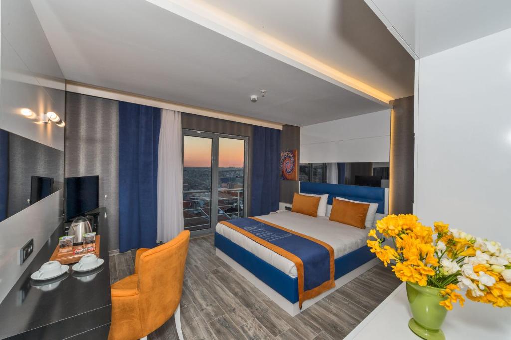 伊斯坦布尔伊斯坦布尔茵特酒店的酒店客房,配有床和鲜花书桌