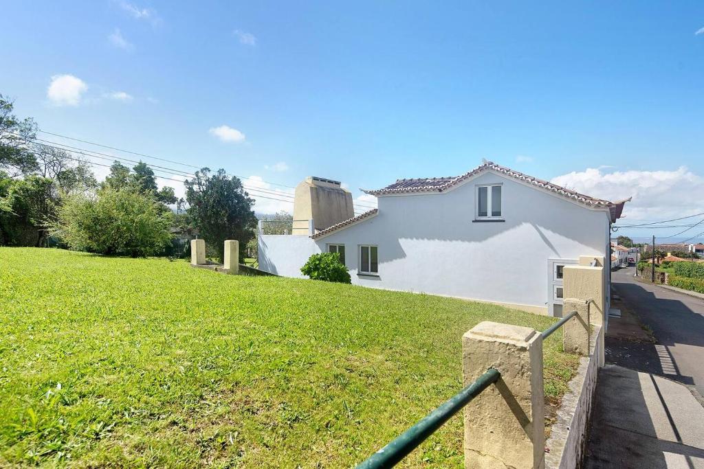 蓬塔德尔加达Casa da Batalha的前面有绿色草坪的白色房子