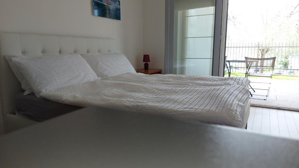 马尔切西内Villa Treccani Apartments的卧室内的一张床位,享有阳台的景色