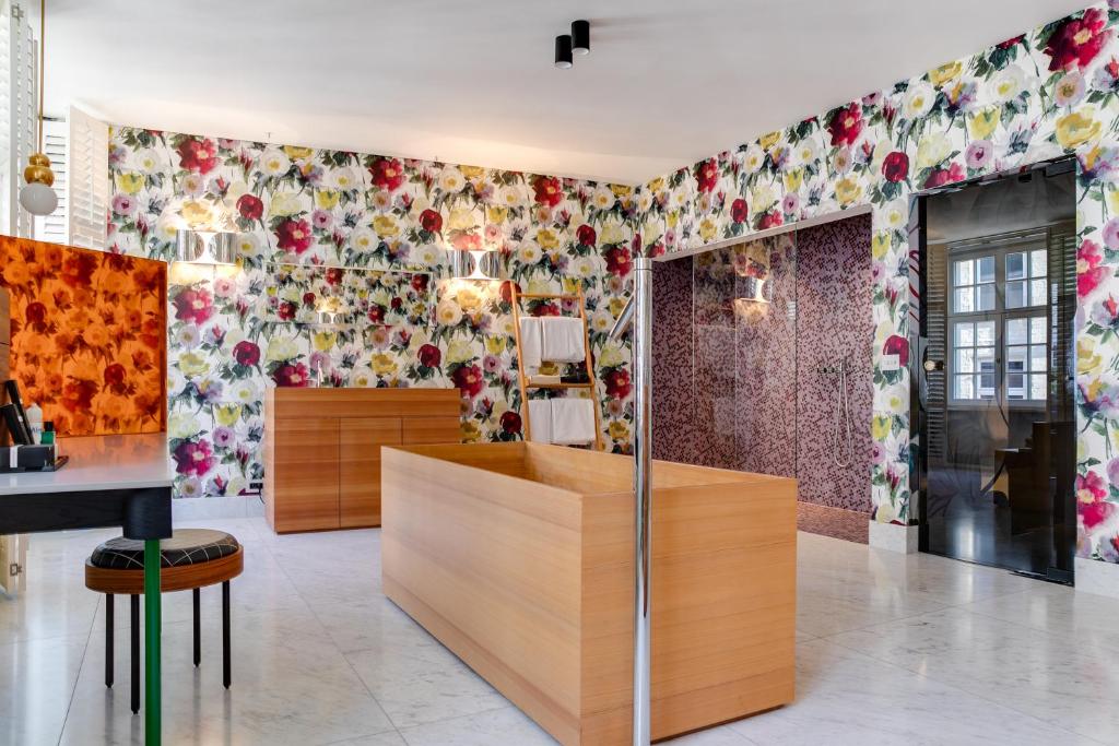 安特卫普Small Luxury Hotel De Witte Lelie的墙上装饰有花卉图案的壁纸的房间