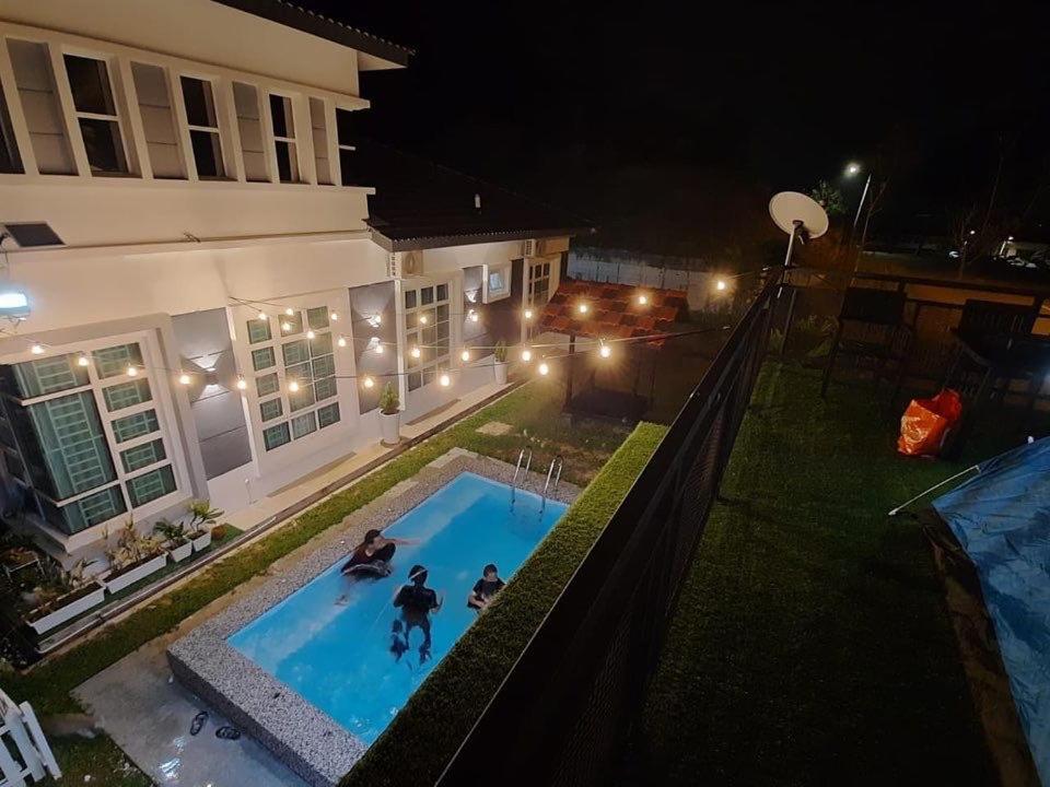 马六甲ADRIANA CABIN的两人在晚上在游泳池玩耍