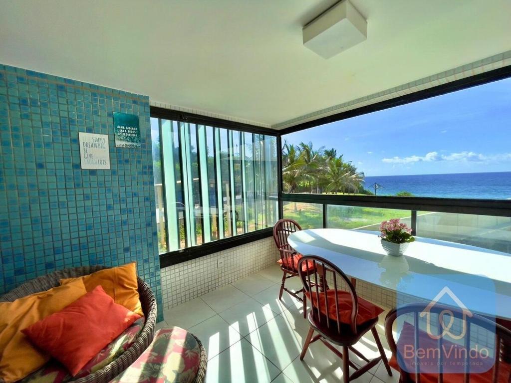 萨尔瓦多Apartamento completo e pé na areia no Rio Vermelho的一个带桌椅的海景阳台