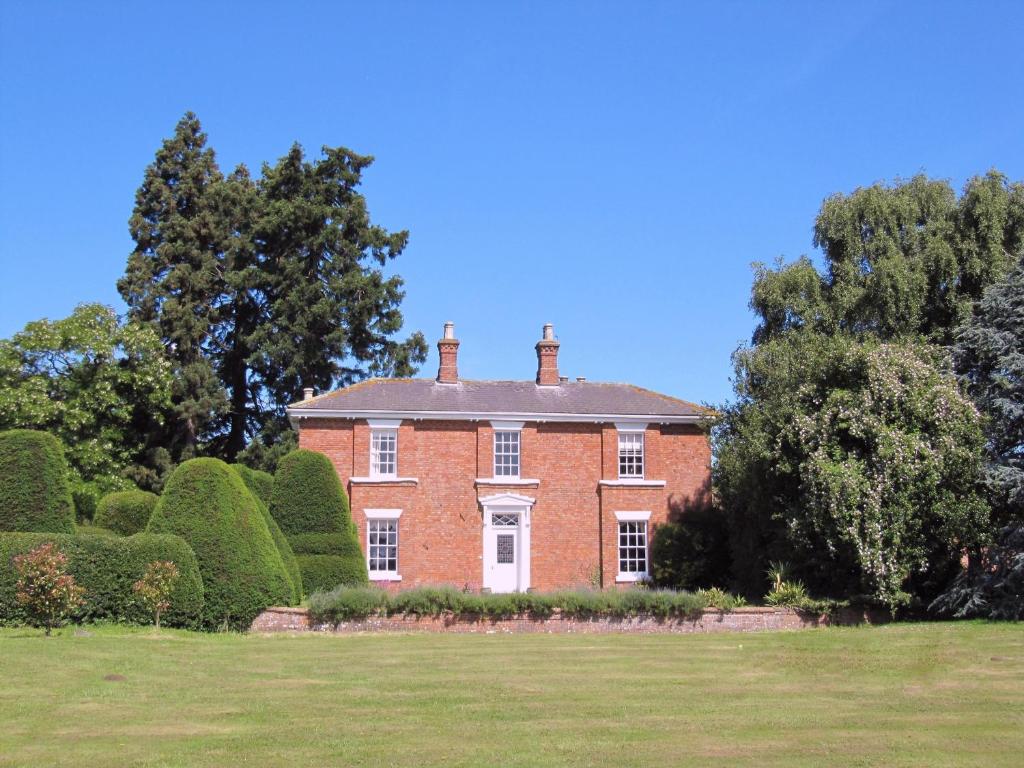 East BarkwithThe Grange的一座大红砖房子,有树木和灌木