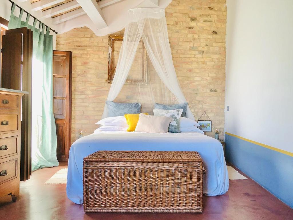 圣安杰洛城Effimera - Relaxing Retreat的一间卧室配有一张大床和柳条箱