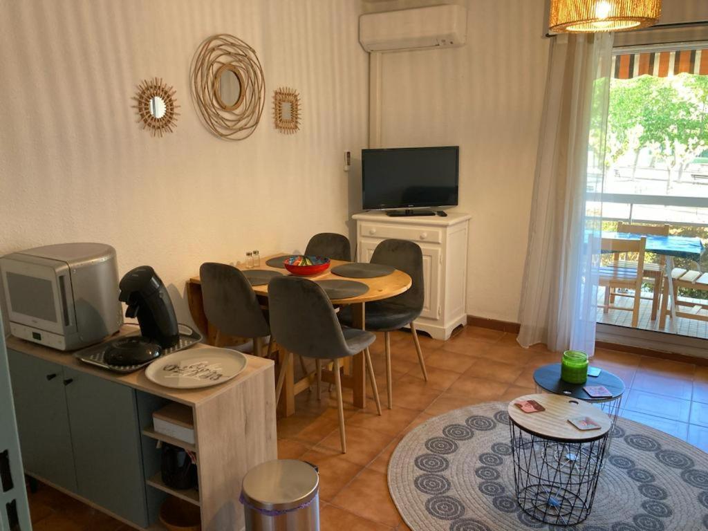 勒拉旺杜studio cabine. Terrasse的客厅配有桌椅和电视。