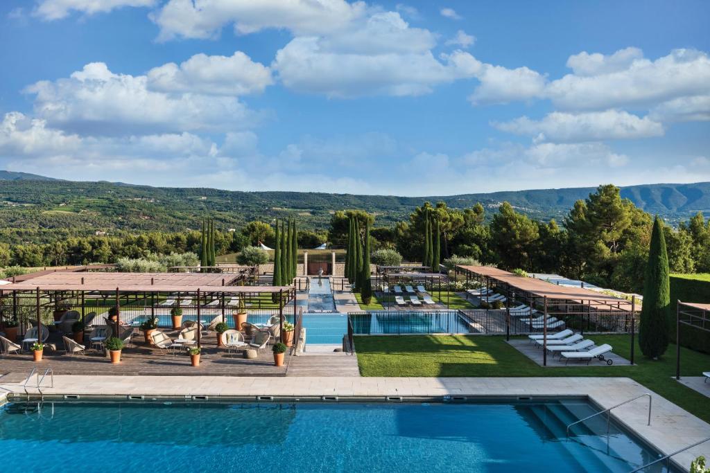 加尔加斯Coquillade Provence的享有游泳池的景色,位于一个以山脉为背景的度假胜地