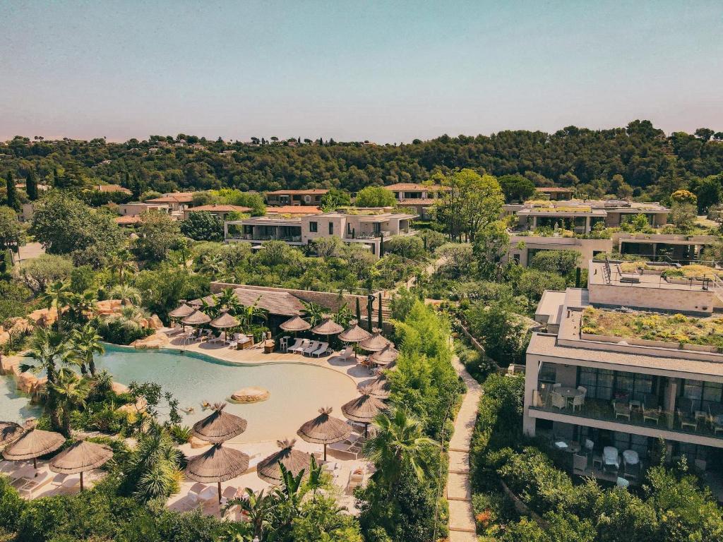 圣保罗-德旺斯Domaine du Mas De Pierre的享有带游泳池和遮阳伞的度假村的空中景致