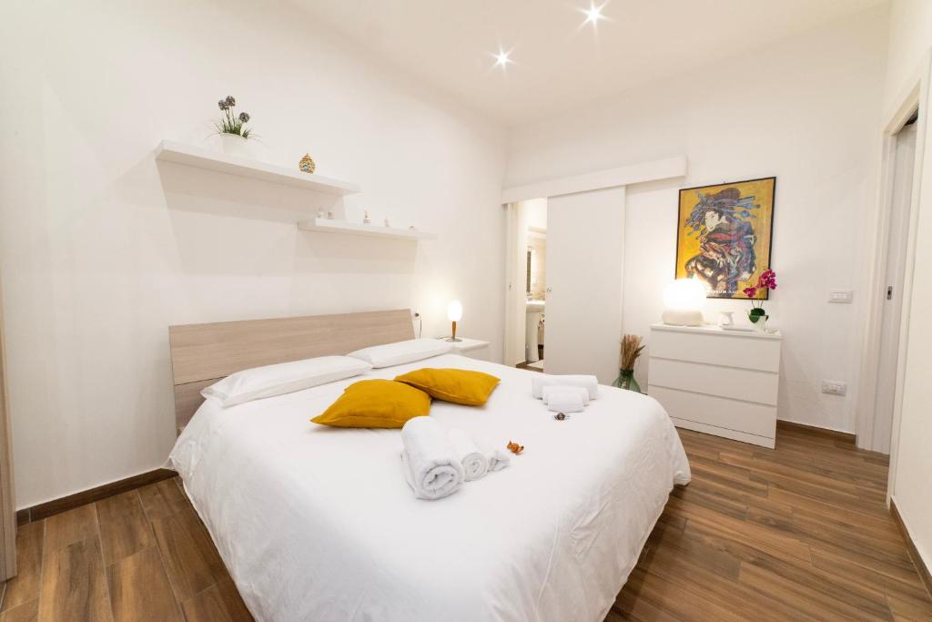 墨西拿Appartamento nel cuore di Messina的白色卧室配有一张带黄色枕头的大床