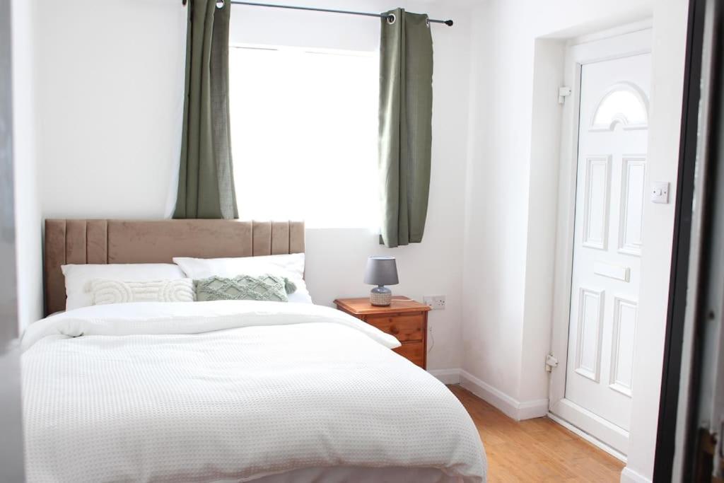 埃尔特姆Self-contained guest suite的卧室配有一张大白色床和窗户