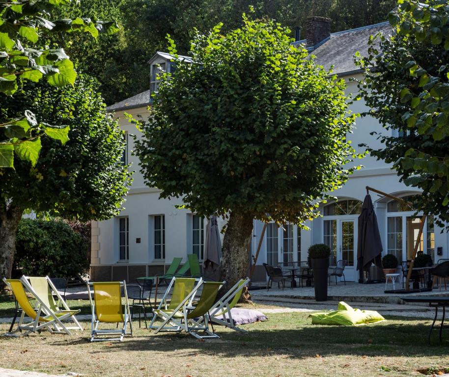 马夫列Les appartements du Domaine de Maffliers 4 étoiles - Demeures de Campagne的一群椅子和一棵树,在一座建筑前