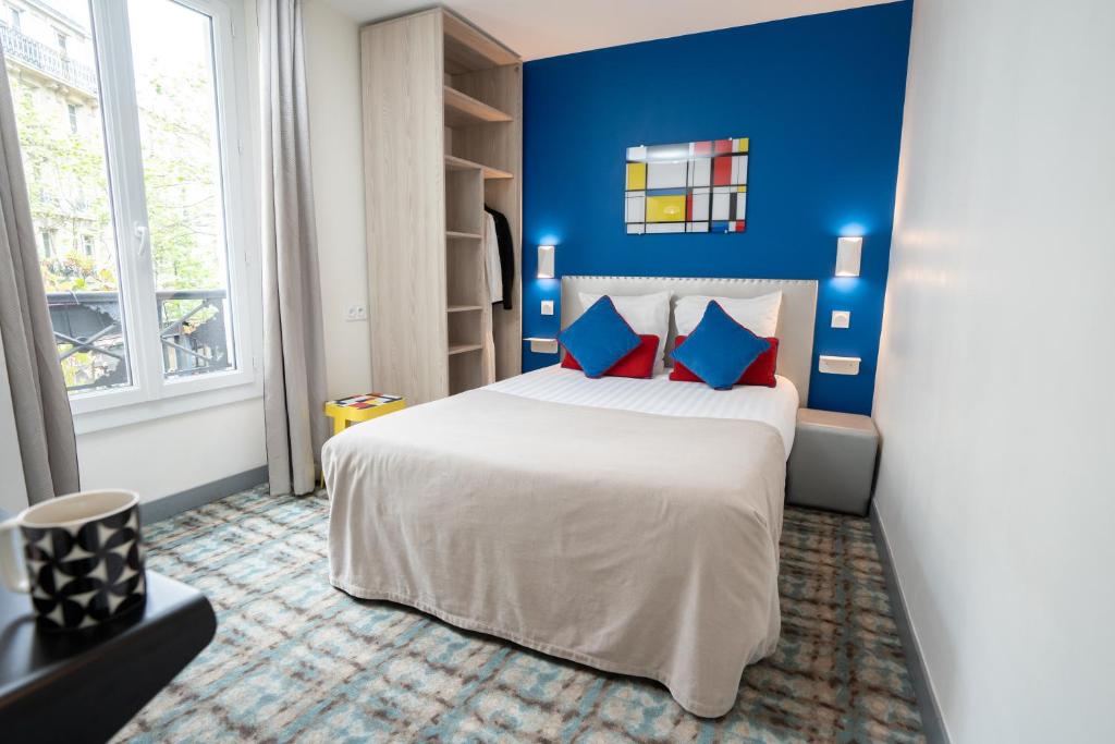 巴黎杜蒙特多尔巴蒂尼奥勒酒店的卧室配有白色大床和蓝色的墙壁