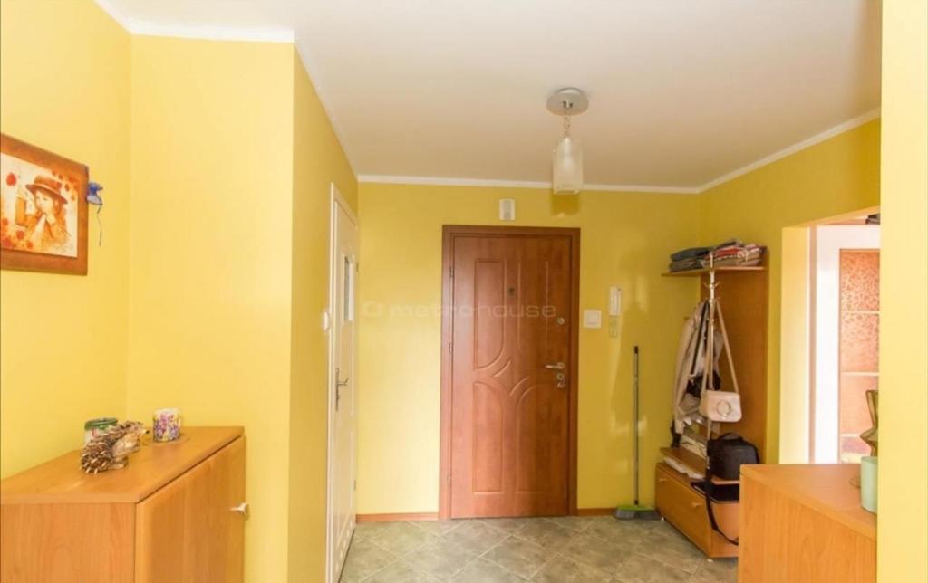 什切齐内克Słoneczny Apartament的一间设有黄色墙壁和木门的房间