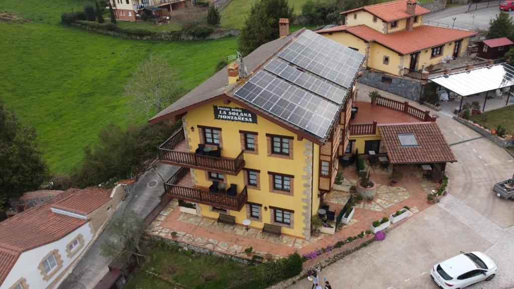 柯米拉斯索兰纳蒙塔涅萨乡村旅馆的享有大型黄色房屋的顶部景色,设有太阳能屋顶