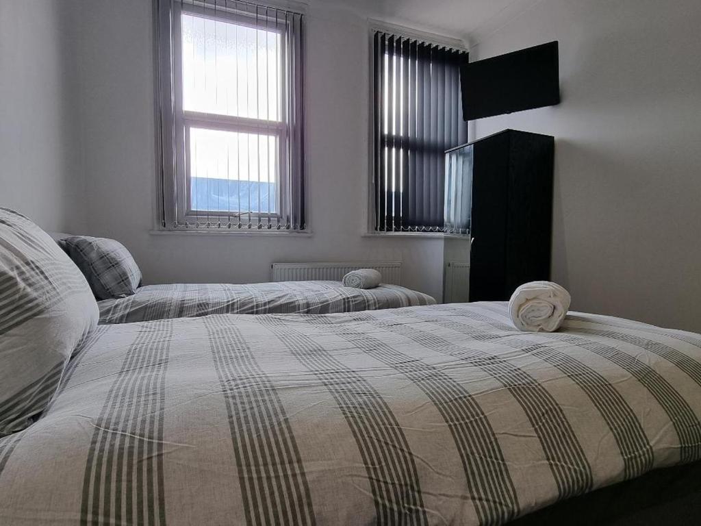 利物浦Portside Liverpool的一间卧室设有两张床和两个窗户。