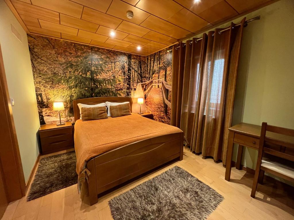 萨布盖鲁Casa do Telheiro的一间卧室配有床和壁画