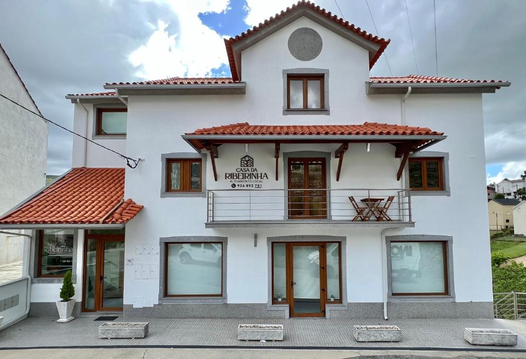 萨布盖鲁Casa da Ribeirinha的白色的建筑,上面有标志