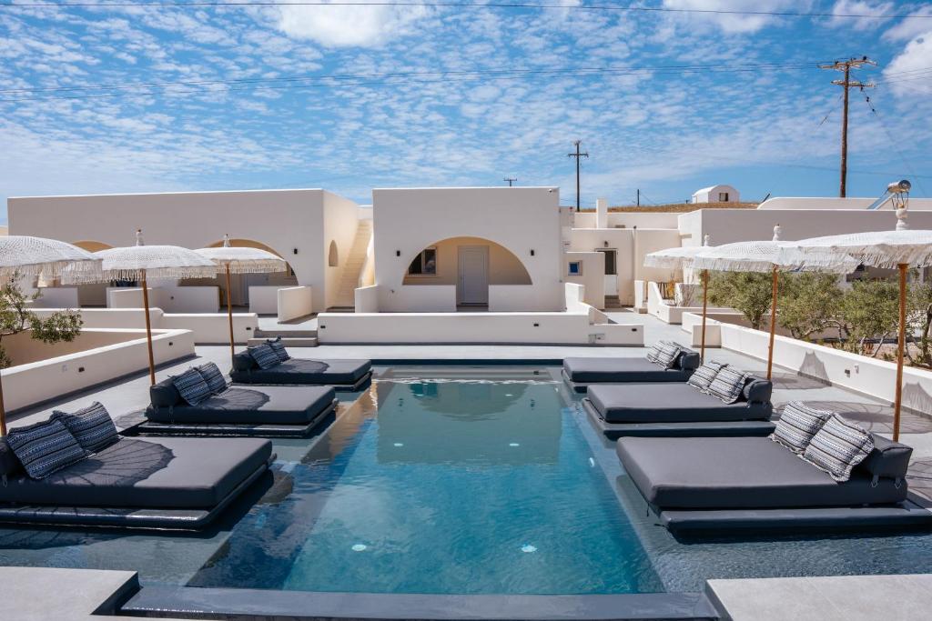 卡特瑞杜斯Zaitun Luxury Suites的度假村内带躺椅和遮阳伞的游泳池