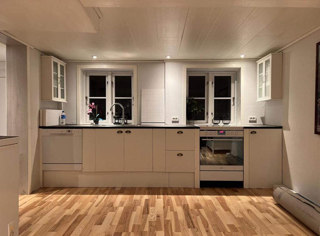 瑟沃格Cory & Torfinn House的厨房铺有木地板,配有白色橱柜。