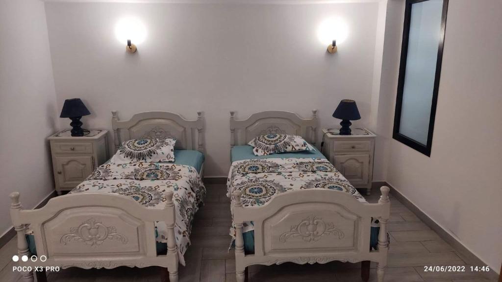 古莱比耶Kelibia beach luxury maison的一间卧室设有两张床和两个床头柜