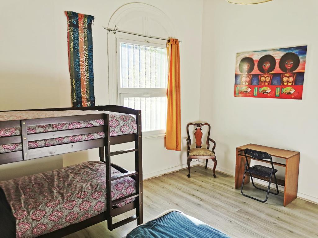 瓦尔帕莱索La Casa Piola的一间卧室配有双层床和椅子