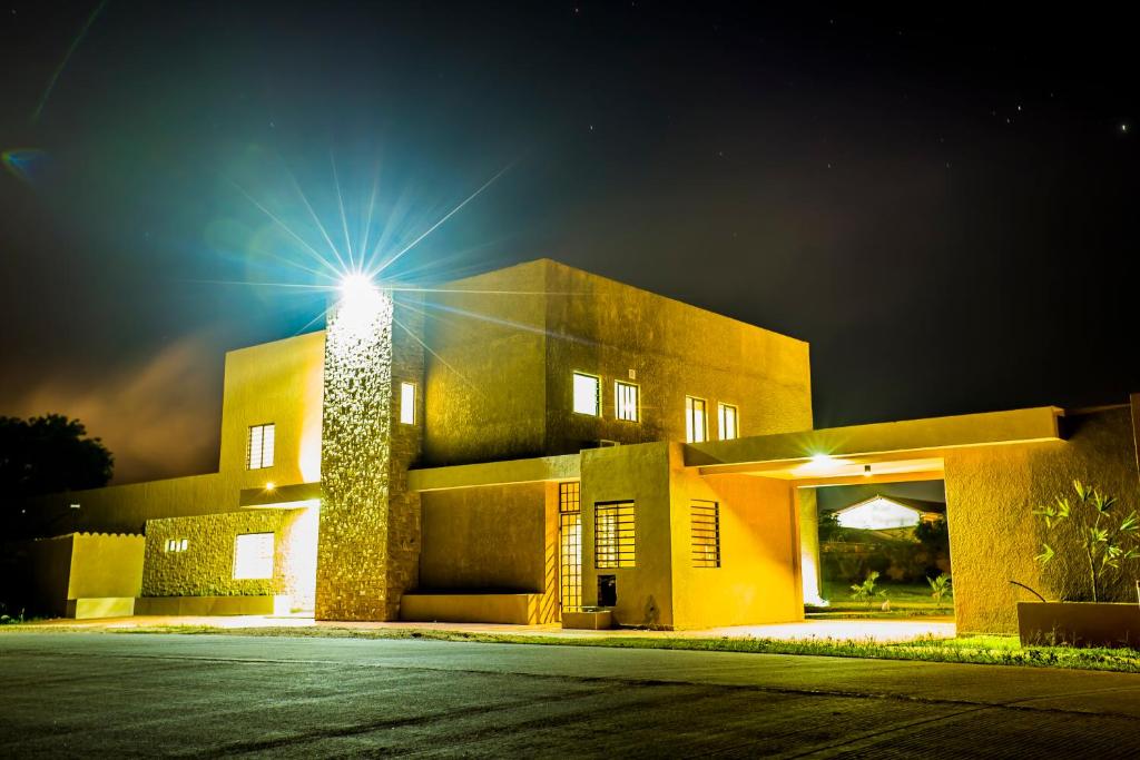 San José de ChiquitosEl Suto Apart Hotel的一座晚上在上面有灯的建筑