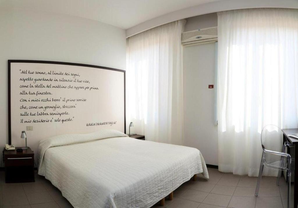 西维尔诺瓦·马尔凯日光浴酒店 的卧室配有白色的床和白色的墙壁