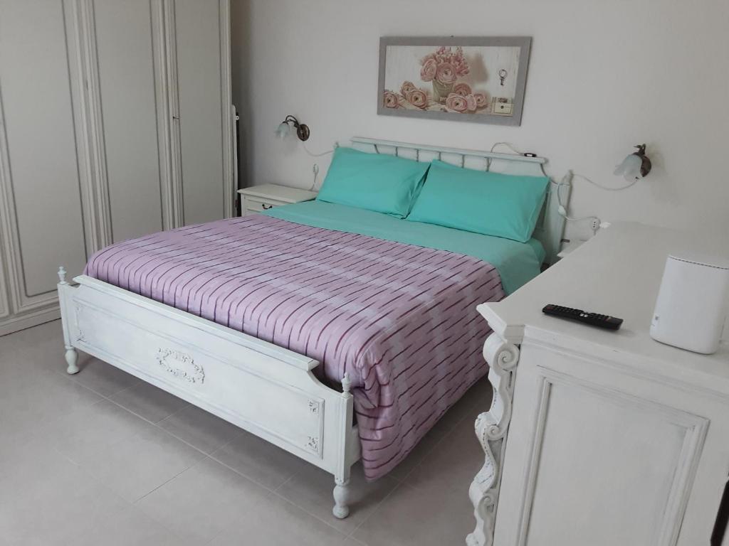 维泰博La casetta nella Tuscia的白色卧室配有一张带紫色毯子的床