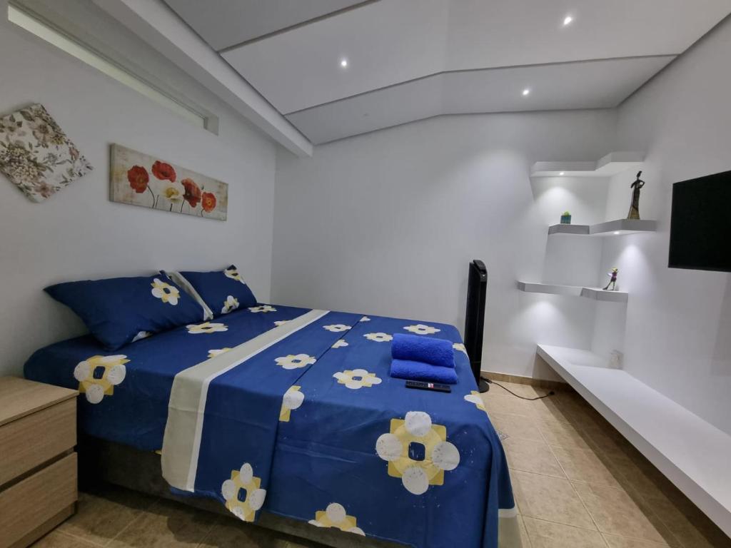卡利Hospedaje Casa Leví的一间卧室配有蓝色的床,铺有蓝色和白色的床单