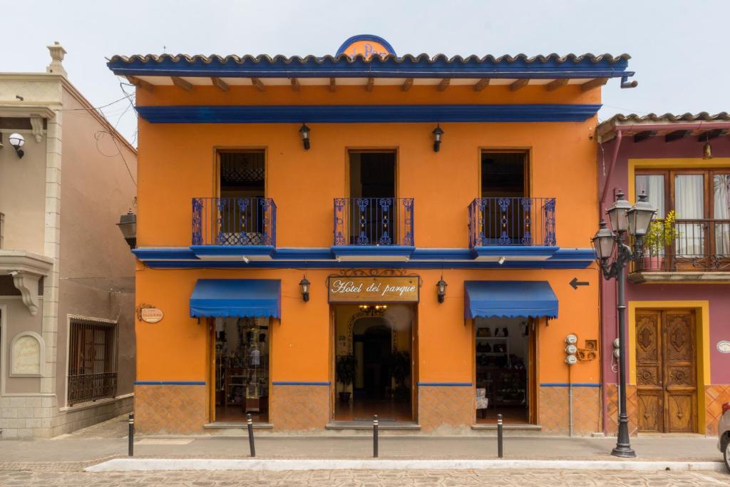 NaolincoHotel del Parque Naolinco的一座橙色的建筑,在街上设有蓝色的阳台