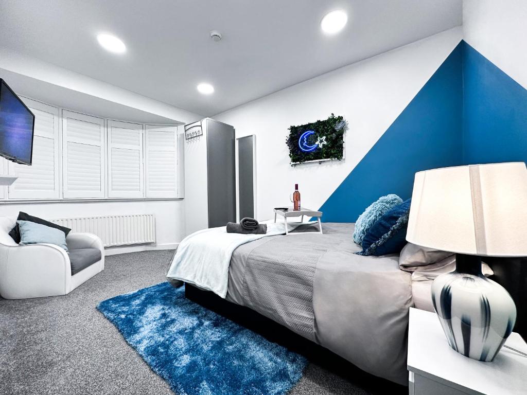 Enfield LockCosy Contemporary Apartment - Brimsdown, Enfield的一间卧室设有一张蓝色墙面的大床