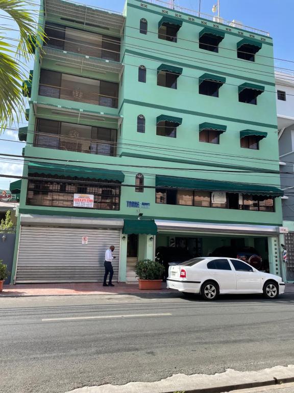 圣多明各托雷斯公寓式酒店的停在大楼前的白色汽车