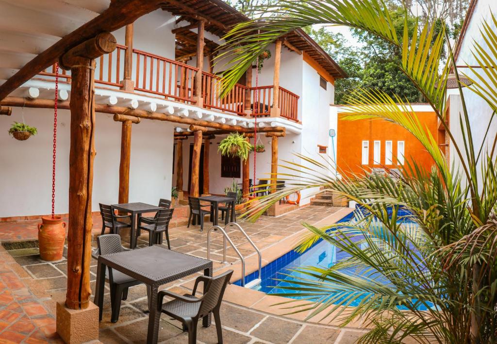 巴里查拉Hotel Tierra Roja By MH的游泳池旁带桌椅的天井