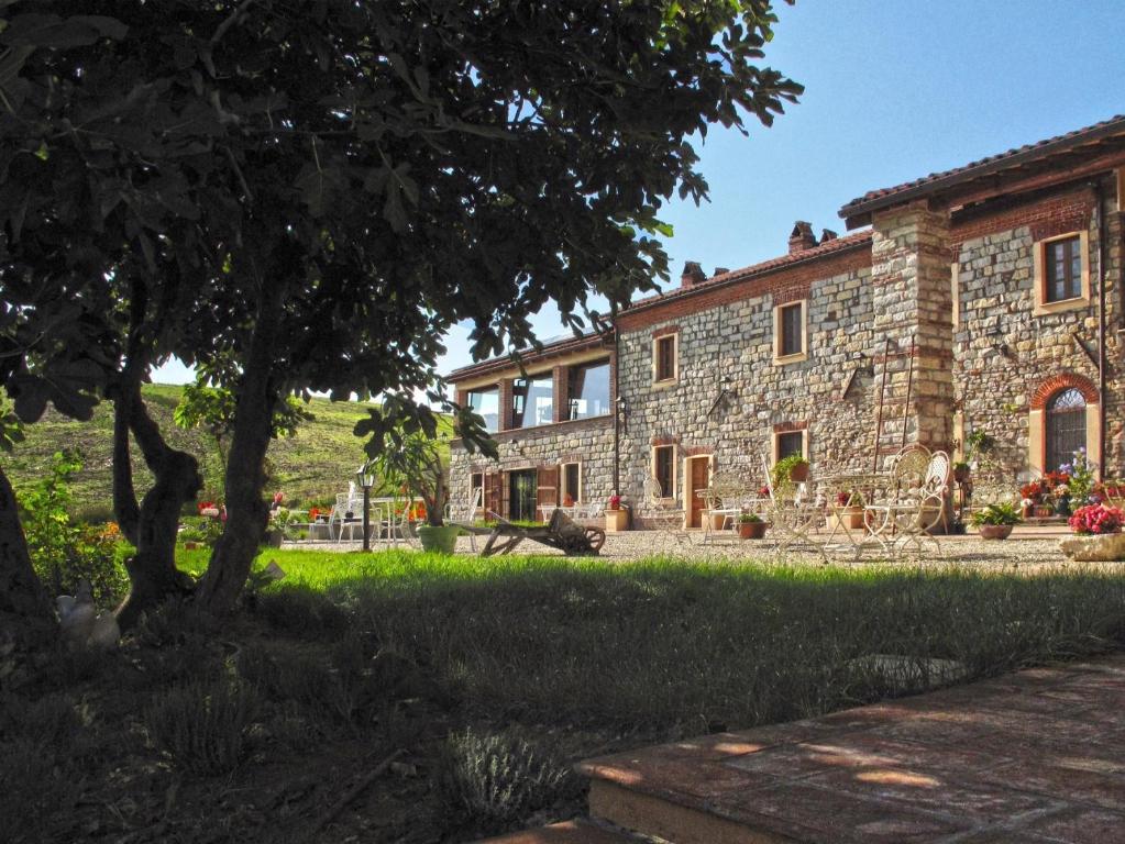 卡萨莱蒙费拉托泰努塔加里托住宿加早餐旅馆的前面有棵树的石头房子