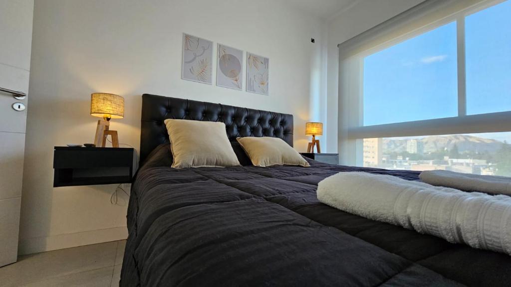 圣路易斯MaJo Apart的一间卧室配有一张带两盏灯的大型黑色床。