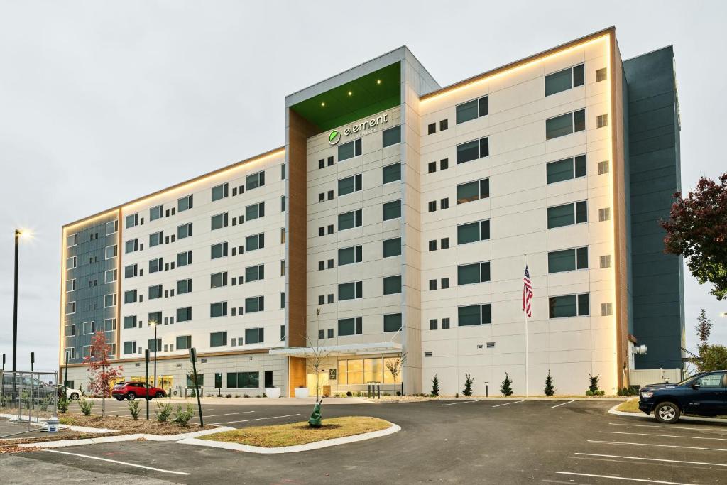 查塔努加Element Chattanooga East的一座白色的大建筑,停车场有停车位