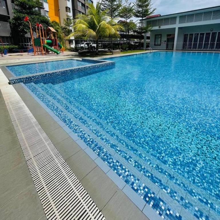 汝来Wallaway2stay Kiara Nilai Apartment 3 Bedroom的大楼内一个蓝色的大型游泳池