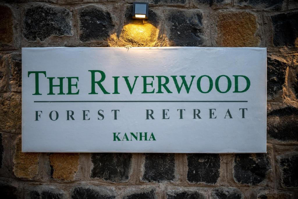 坎哈The Riverwood Forest Retreat - Kanha的挂在砖墙上的河木森林静修标志