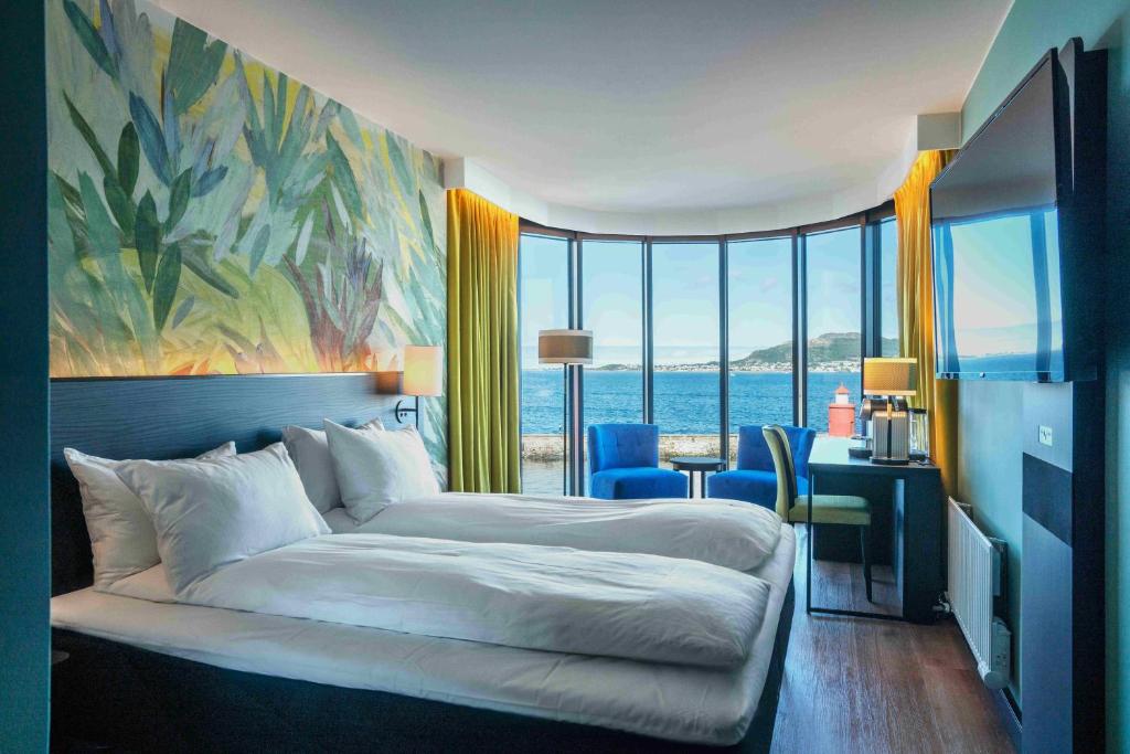 奥勒松Thon Hotel Ålesund的一间卧室配有一张床、一张书桌和一个大窗户