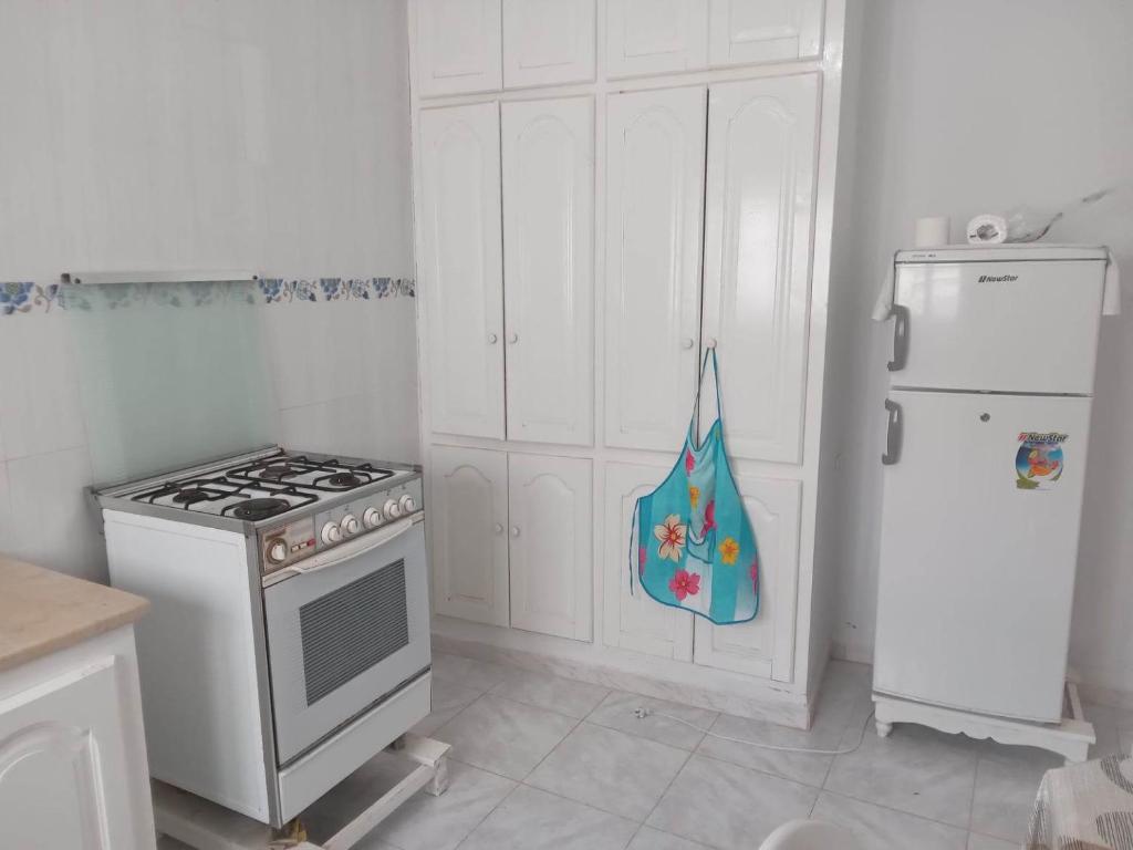 古莱比耶Confortable Maisonnette prés de la plage à Dar el Alouch的厨房配有炉灶和冰箱。