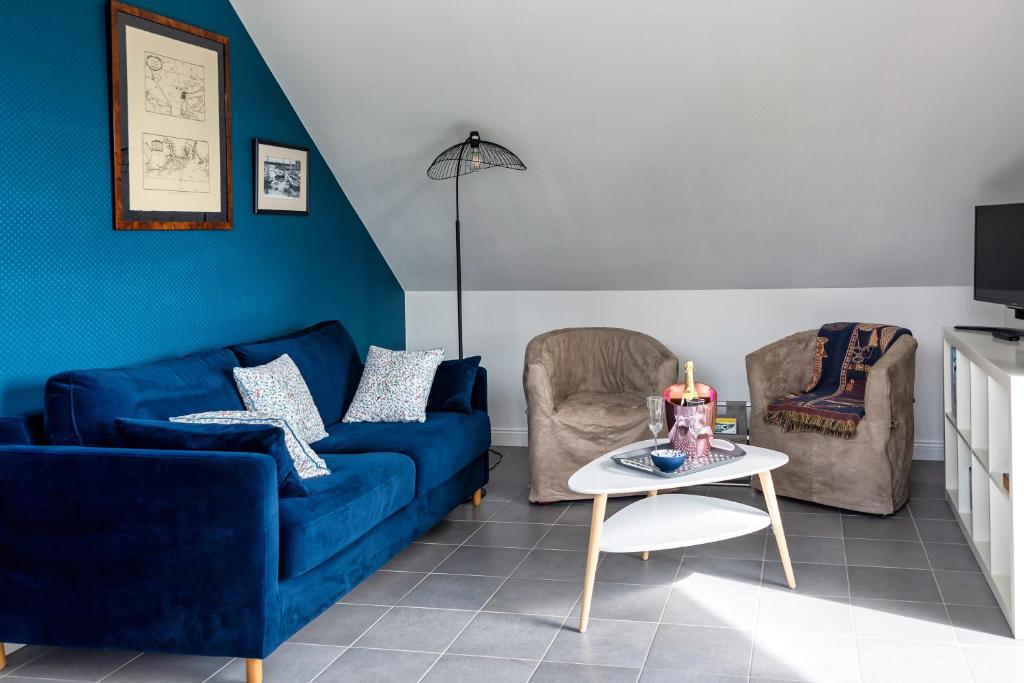 康卡勒L'Abri du Bon Vent的客厅配有蓝色的沙发和两把椅子