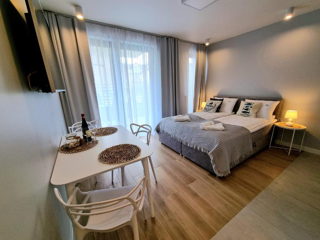 米兹多洛杰Baltic Soul Villa的一间小卧室,配有床、桌子和桌子
