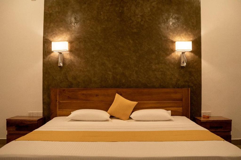 哈伯勒内Lina Hotel的卧室配有一张床,墙上挂着两盏灯