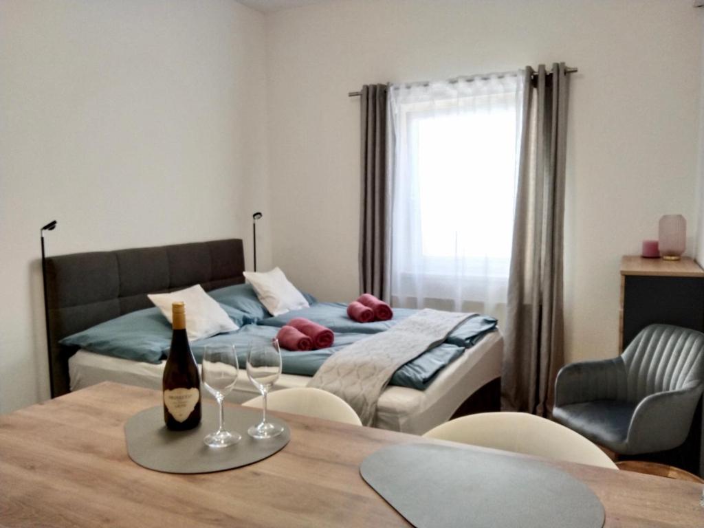 圣珀尔滕Ruhiges Ferienapartment mitten im Zentrum Sankt Pölten的一间卧室配有一张床和一张带酒杯的桌子